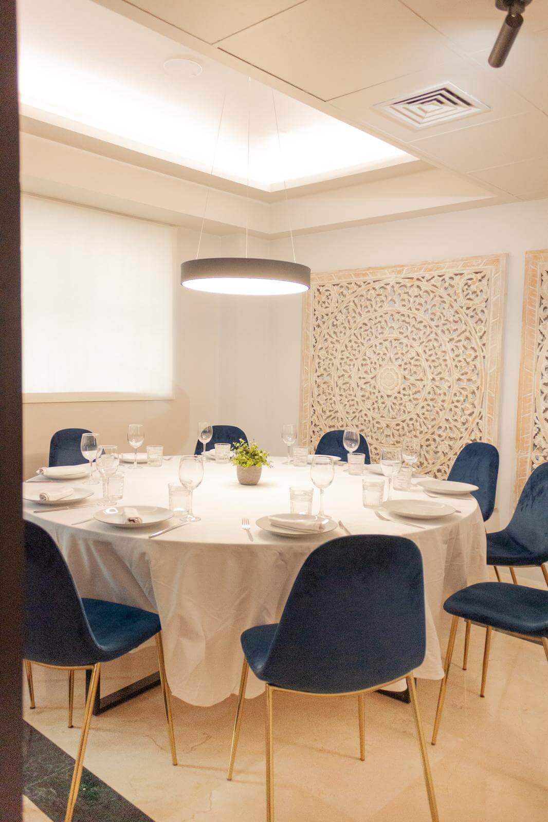 Salón privado de La Reinosa con mesa redonda y celosía de madera al fondo