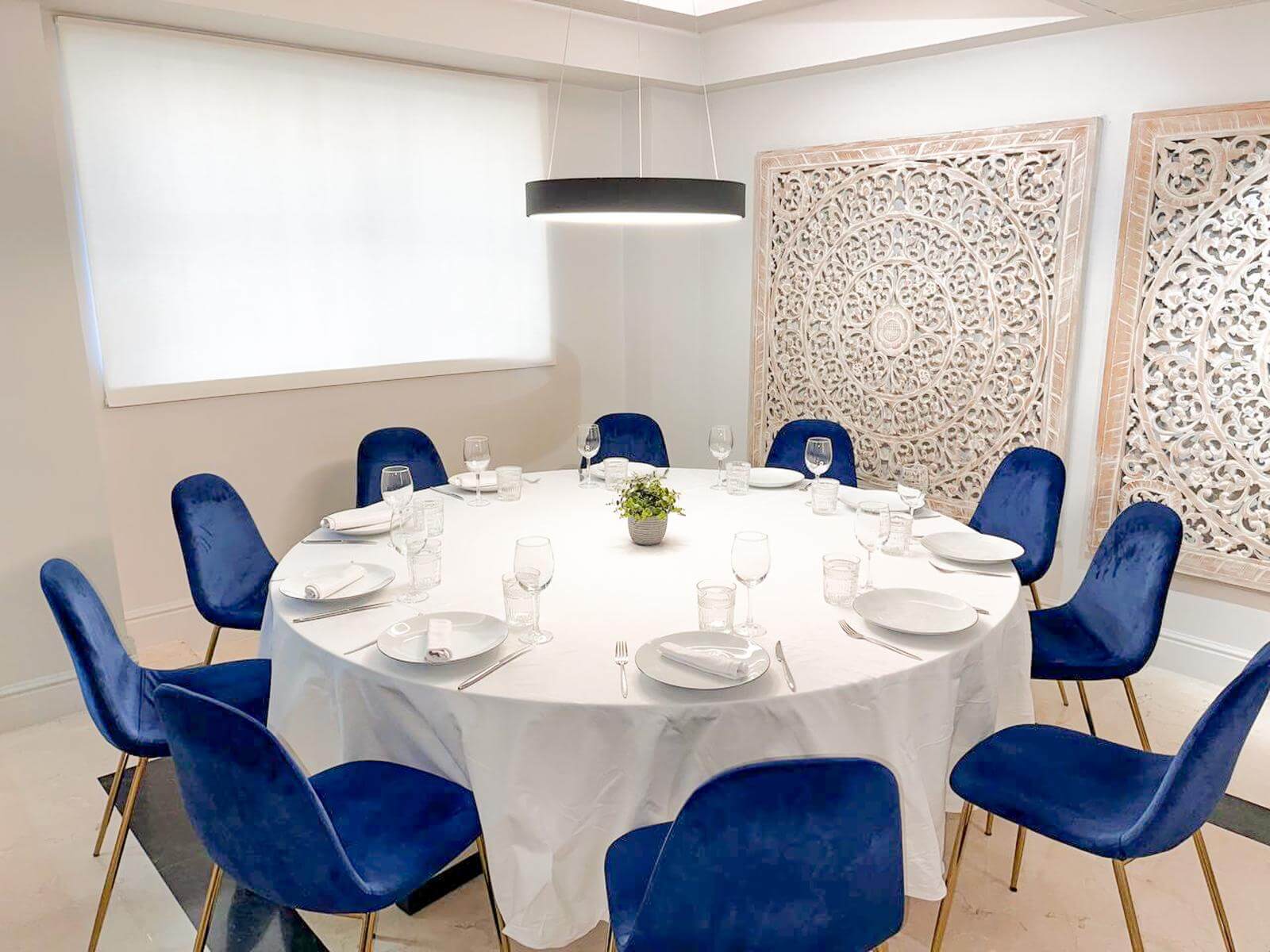 Salón privado de La Reinosa con mesa redonda y sillas de terciopelo verde