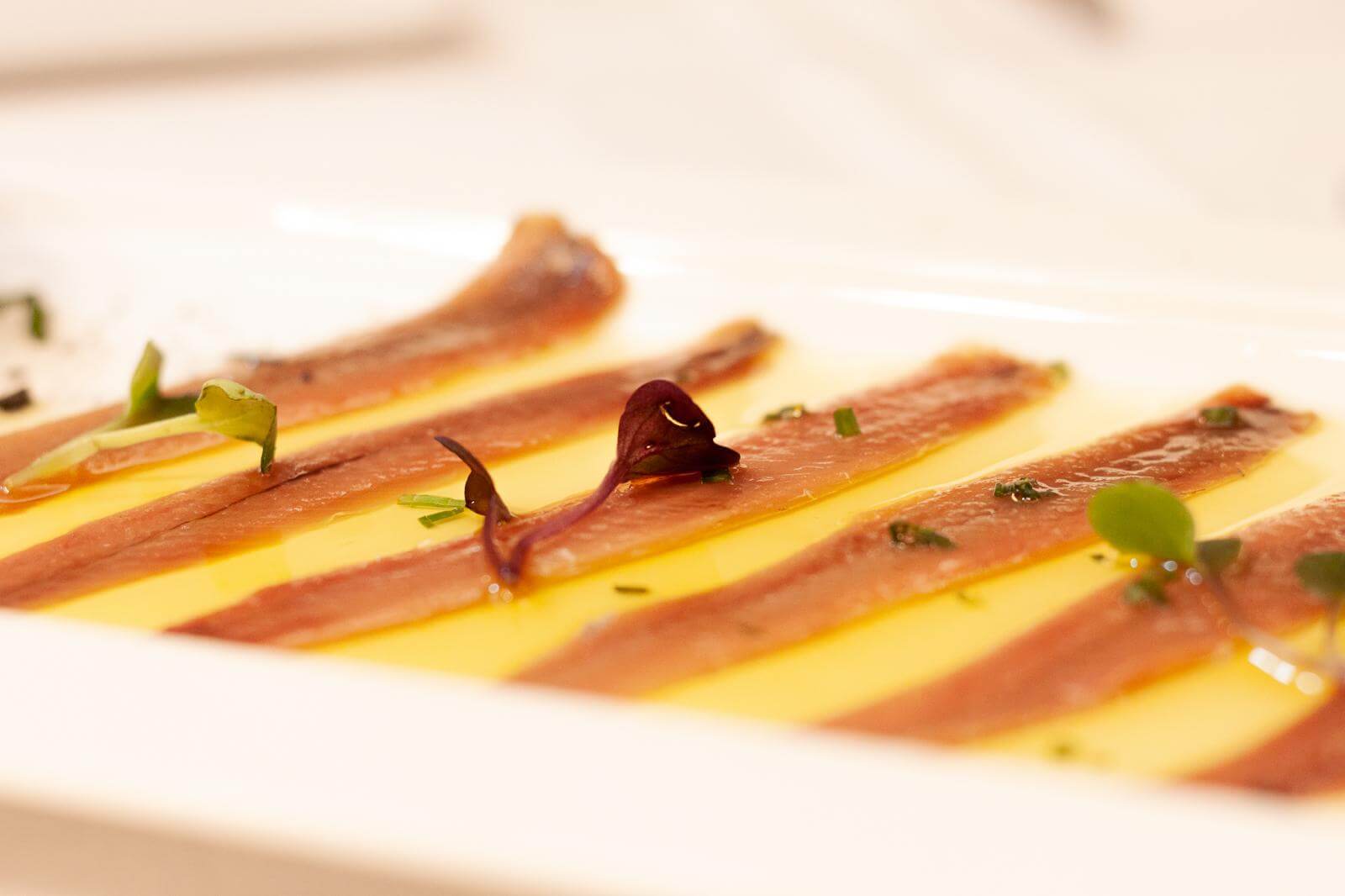 Anchoas de Santoña sobre tostas de pan de cristal con tomate rallado, en La Reinosa