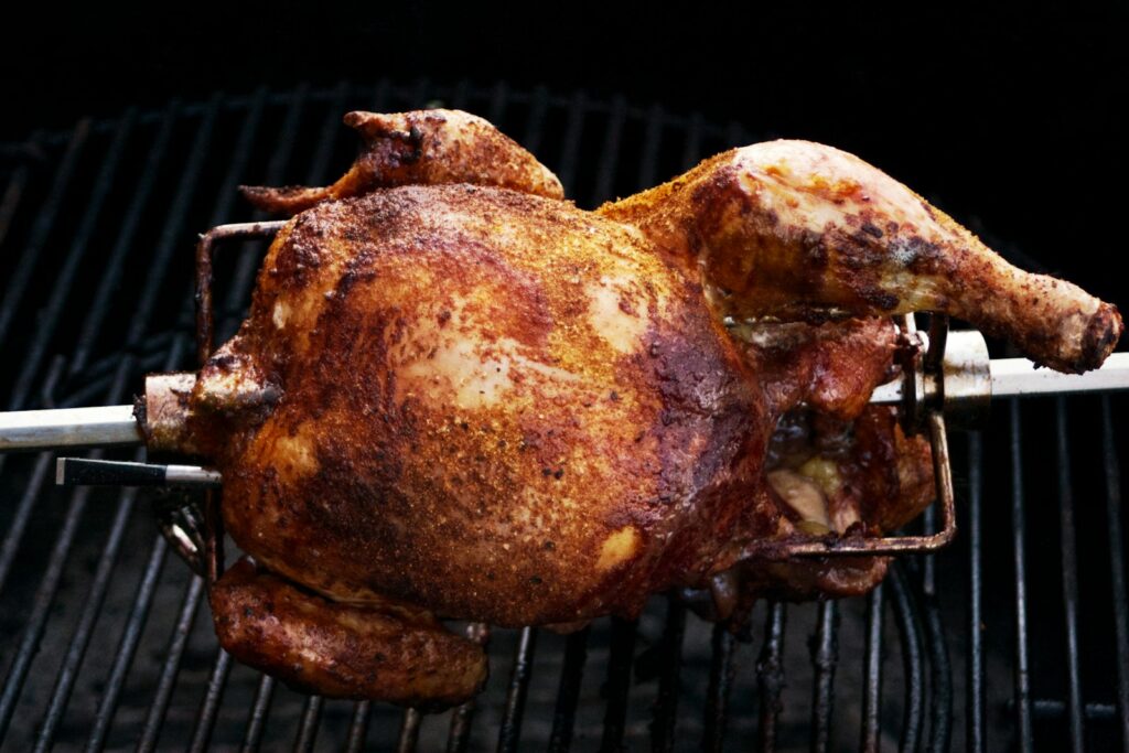 Pollo entero haciéndose sobre brasa de carbón