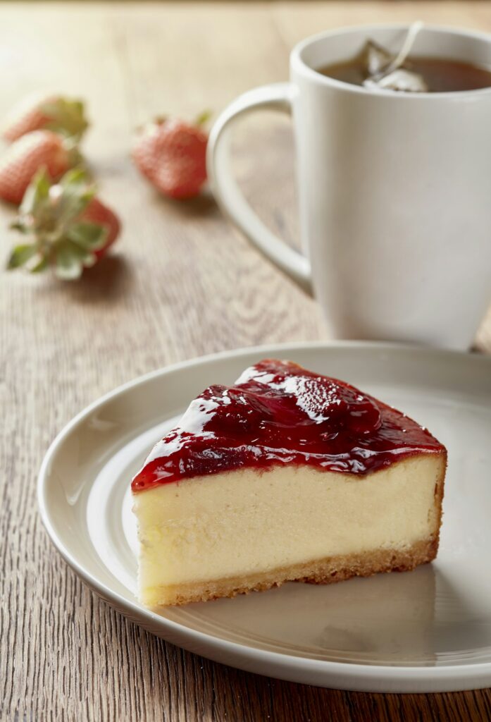 Porción de tarta de queso con un café solo
